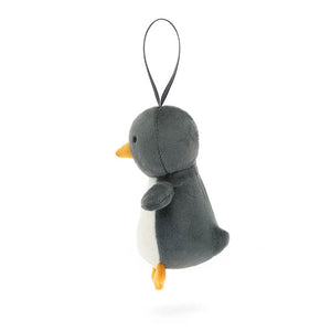 Side view of the Jellycat Festive Folly Penguin highlighting its tiny flippers, orange feet, and slate grosgrain ribbon for tree hanging