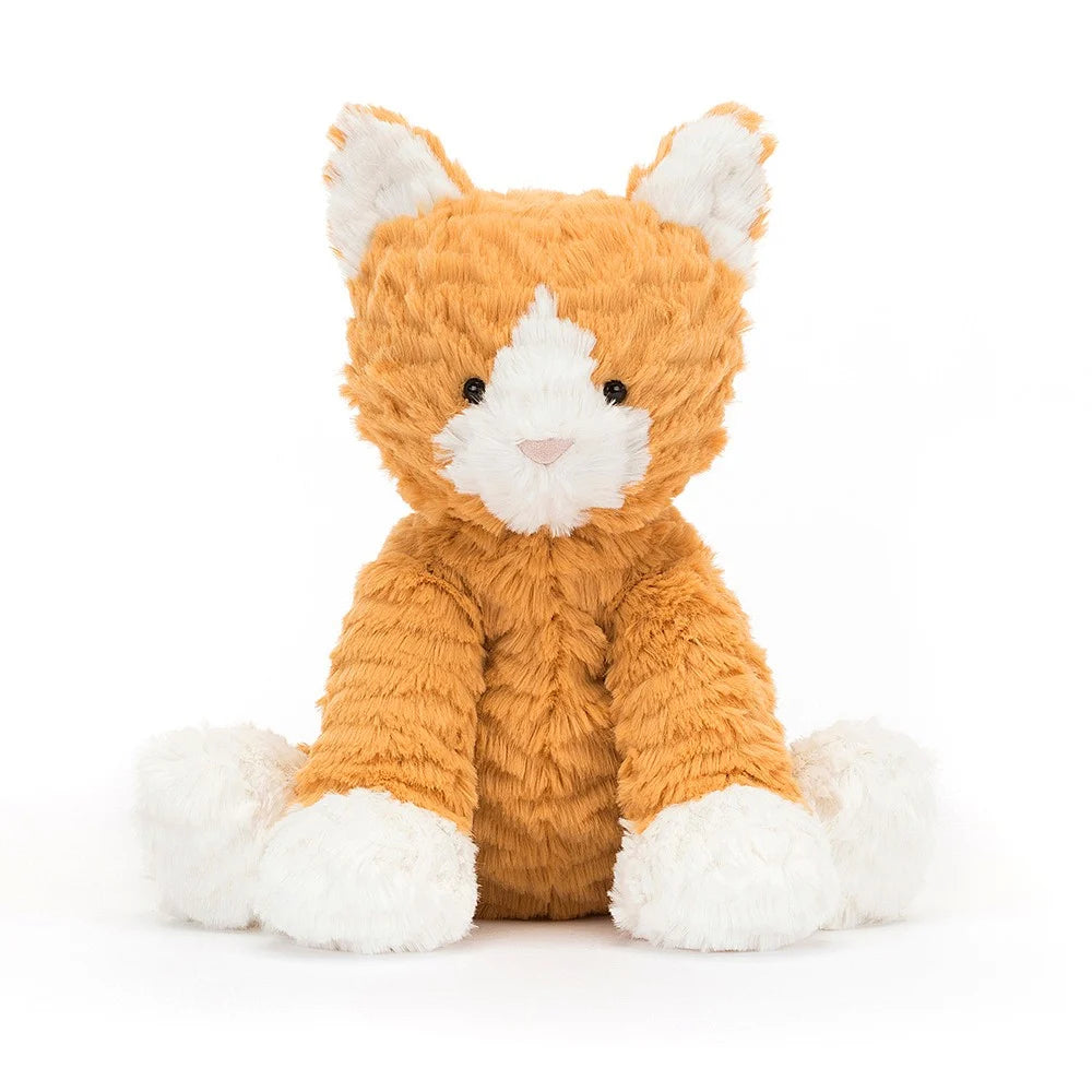 Image of Jellycat Fuddlewuddle Ginger Cat plush toy. The cat has soft, marmalade fur with hints of cream and marshmallow paws. It has bright, inquisitive eyes, a pink suede nose, and a bean-filled bottom. The cat's ears are pointed and its fur is tousled, giving it a playful appearance.