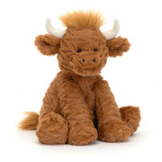 Angled View: Hodgepodge of fun! The Jellycat Fuddlewuddle Highland Cow leans in, showcasing its delightfully tousled toffee fur with perky vanilla horns. Floppy petal ears, a friendly stitch grin, and weighted hooves complete the playful charm. Moo-ve over for cuddles!
