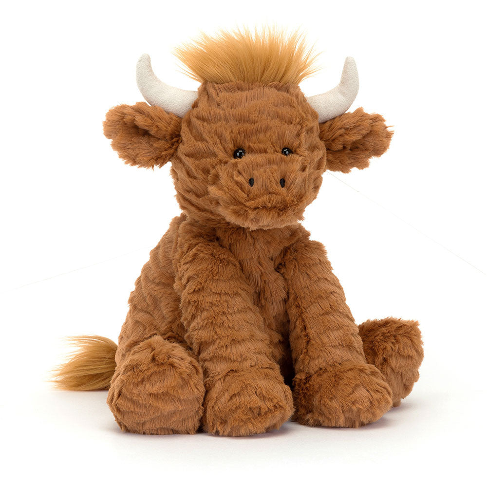 Angled View: Hodgepodge of fun! The Jellycat Fuddlewuddle Highland Cow leans in, showcasing its delightfully tousled toffee fur with perky vanilla horns. Floppy petal ears, a friendly stitch grin, and weighted hooves complete the playful charm. Moo-ve over for cuddles!