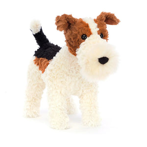 Front: A super soft and cuddly Jellycat Hector Fox Terrier with perky brown ears, a wagging black tail, and a mischievous glint in his embroidered eyes. His fur is a playful mix of cream, brown, and ginger with a delightful texture.