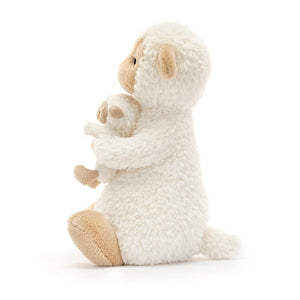 Side view of Jellycat Huddles Sheep, showcasing its fluffy vanilla fur and gentle expression.