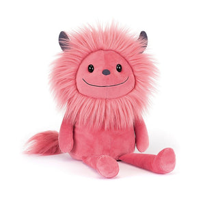 Front: A vibrantly pink Jellycat monster named Jinx with a fluffy pink mane, blue-grey horns, a goofy grin, and a cute tassel tail.