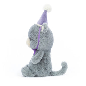  Side view of the Jellycat Jollipop Cat, highlighting its soft bluey-grey fur, huggable build, perky tail, and a fancy hat with a pompom