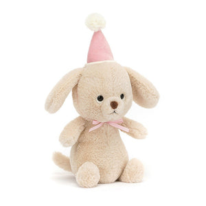 Angled View: Party pup, ready to rest! The Jellycat Jollipop Puppy sits at an angle, showcasing its soft honeycomb fur, berry-pink party hat, and wagging tail.