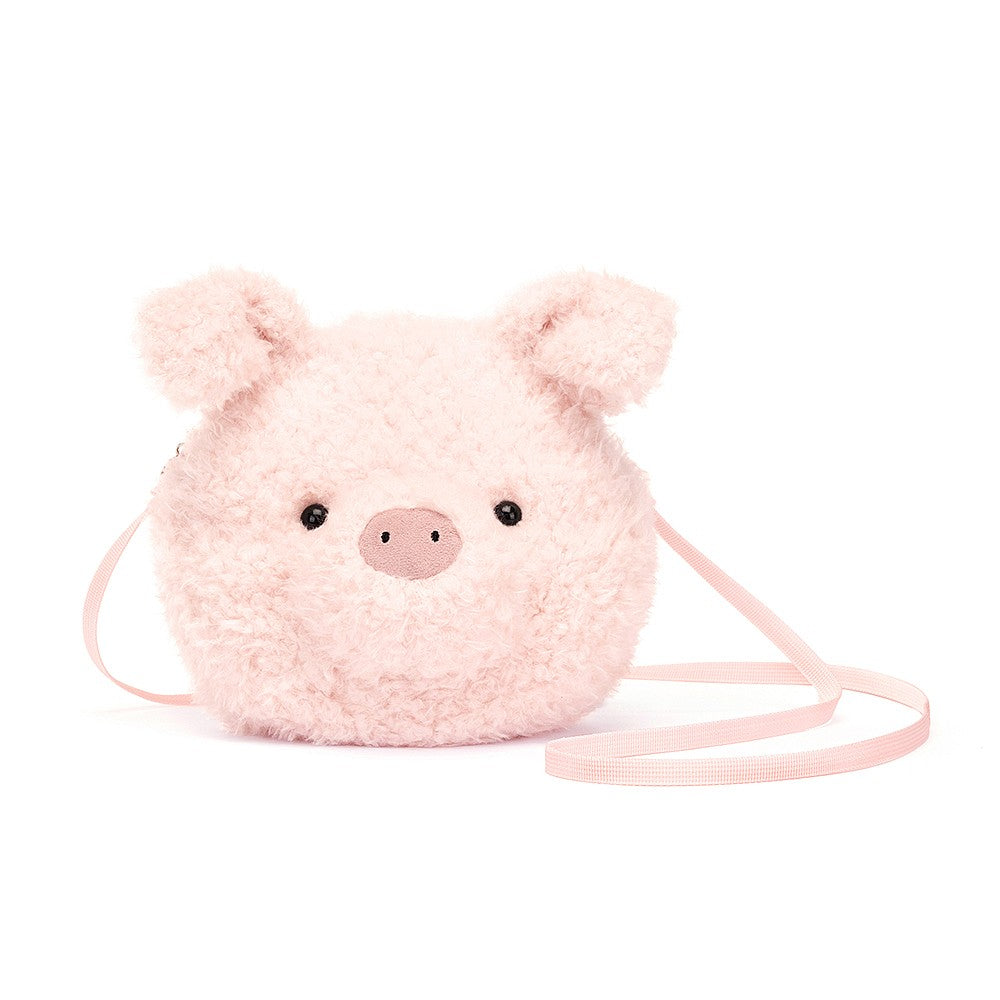 Jellycat Little Pig Bag, a small, plushbag shaped like a pigs head with soft pink fur and an embroidered snout. The bag has adjustable straps and a spacious interior compartment.