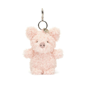 Jellycat Little Pig Bag Charm, a small, plush pig keychain with soft pink fur, fuzzy hooves, and an embroidered snout. The pig is standing upright with a playful expression.