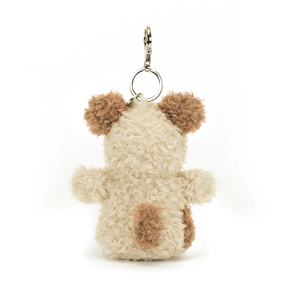 A rear view of A side view of Jellycat Little Pup Bag Charm. The small, plush puppy has fluffy nougat fur with a brown tail. It is attached to a silver clasp.