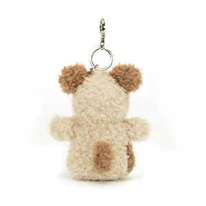 A rear view of A side view of Jellycat Little Pup Bag Charm. The small, plush puppy has fluffy nougat fur with a brown tail. It is attached to a silver clasp.