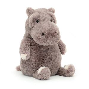 Angled View: Jellycat Myrtle Hippopotamus playfully showcasing its round, huggable form in dusky mauve fur. Rumpled brows, ruched nostrils, and rose paw-patches add personality. A sweet tail wags hello! 