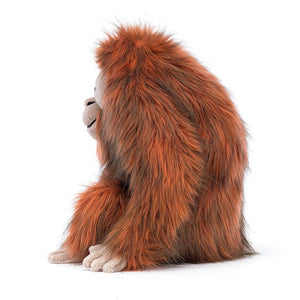 Side view: Swing into fun! This cuddly Jellycat plush, Oswald Orangutan, features shaggy fur, a friendly smile, and long arms perfect for hugs.