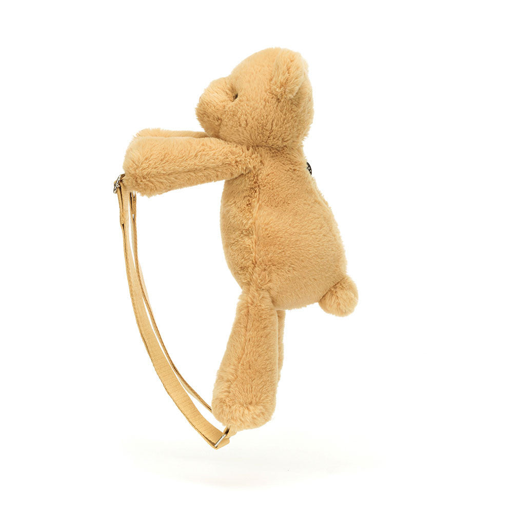 Side profile of Jellycat Smudge Bear Backpack showing soft plush texture and strap shape.