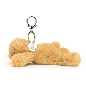 Side View: Side profile of the cuddly Jellycat Smudge Bear Bag Charm. Highlights the compact size, the luxuriously soft texture perfect for squeezing, and the adorable details like the holdable paws, bobble tail, and secure silver claw clip. A charming friend for any adventure!