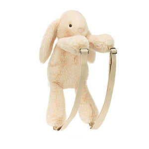 Angled View:  Oatmeal colored Jellycat Smudge Rabbit Backpack tilted slightly, showcasing its long floppy ears, soft fur, and adjustable beige straps. Perfect for carrying essentials on adventures!