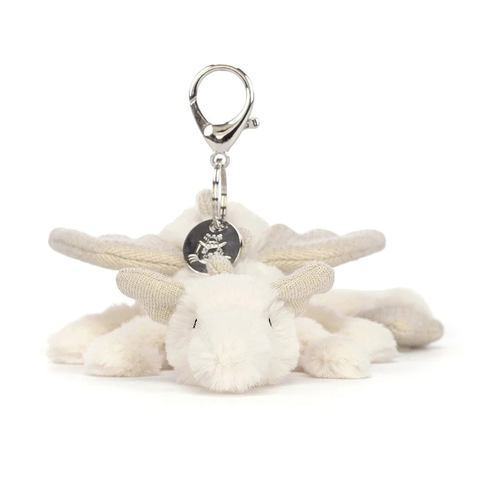 A close-up of the Jellycat Snow Dragon Bag Charm, showcasing its soft fur, sparkling details and silver clip and charm.