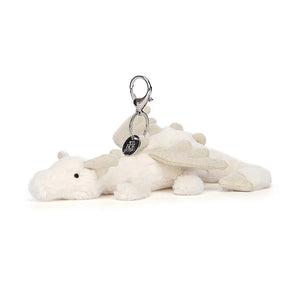 Jellycat Snow Dragon Bag Charm. It has fluffy white fur, sparkly silver wings, spines and ears, and  a silver clip and jellycat charm.