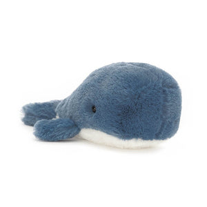 Angled View: Ready to set sail! The Jellycat Wavelly Whale Blue leans at an angle, showcasing its deep blue fur, cloudy-soft head, and fuzzy flippers. 