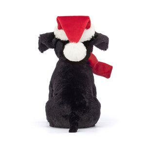 Behind: Cuddly Jellycat Winter Warmer Pippa Lab (back view): Black Labrador plush with red bow & fleece hat.