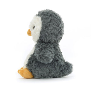 A side view of the Jellycat Yummy Penguin, showing its playful pose and soft, white fur.