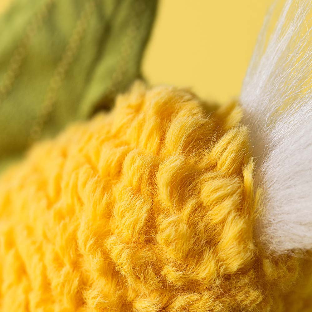 Close-up of Jellycat sweetcorn textured yellow fabric and silk tassel