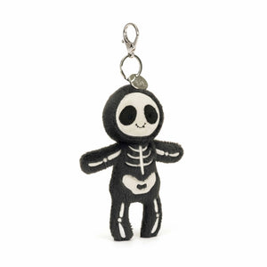 Angled: Skeleton Bob bag charm (angled view) with charcoal fur & embroidered bones. Spooky & cute bag accessory. (