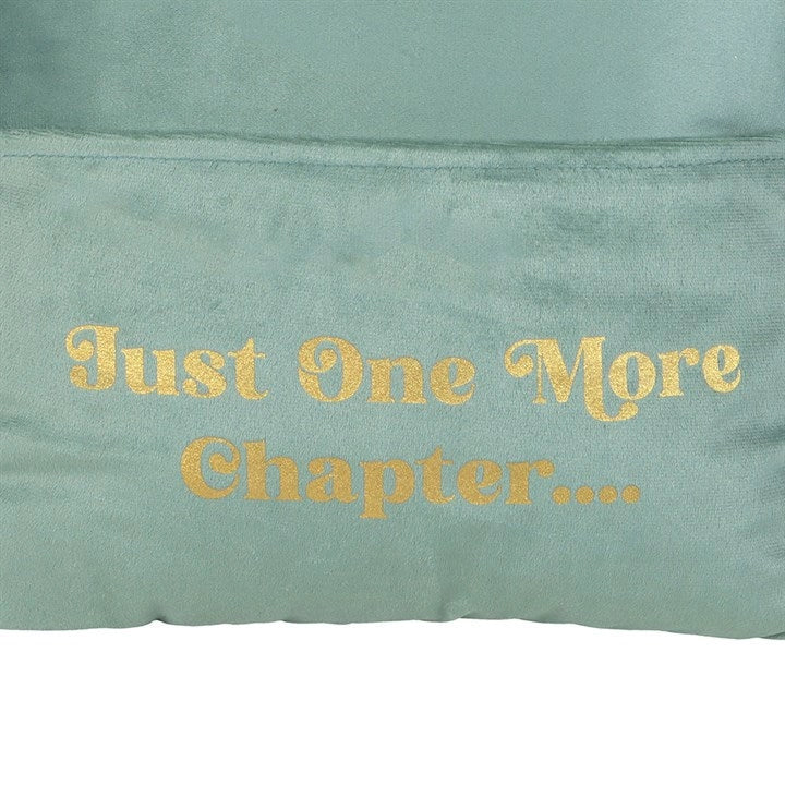Close-up of “Just One More Chapter” text on green cushion.