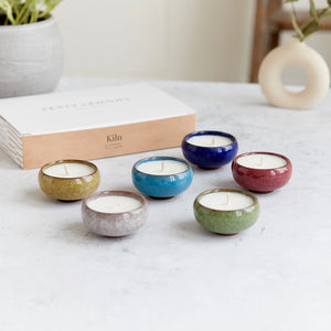 Kiln ceramic tea lights in six colours displayed in front of a Zesty Lemons branded gift box, ideal for candle lovers.