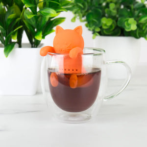 Kit-Tea Infuser cat design perched on glass mug of tea.
