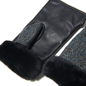 Angled: Ladies' Harris Tweed® & leather mittens (angled view) with Black sheepskin cuffs in black and grey  Herringbone. Warm winter gloves.