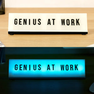 Light-up desk plaque showing day and night mode, black letters on white background and glowing blue light version.