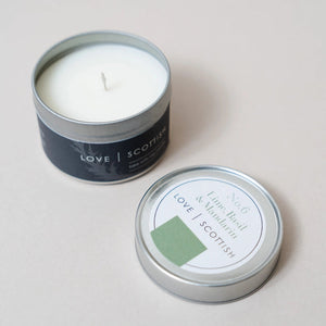 Lime Basil & Mandarin soy wax candle tin with lid off, showing creamy white wax in a brushed silver container.