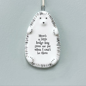 East of India porcelain hedgehog hanging plaque with a heartfelt message - ‘Here’s a little hedge hug from me for when I can’t be there.’ A thoughtful gift for friends, family, and loved ones.