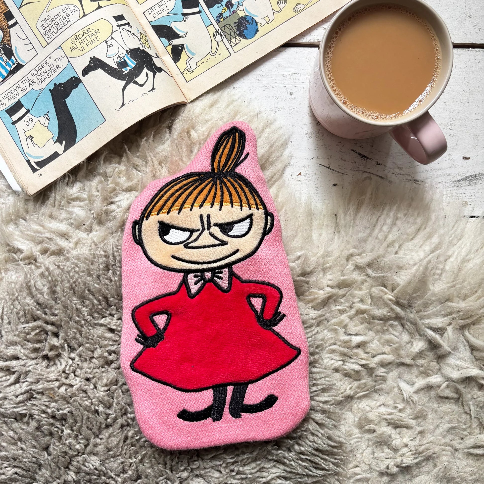 Little My Mini Hot Water Bottle on cosy rug with book and tea.