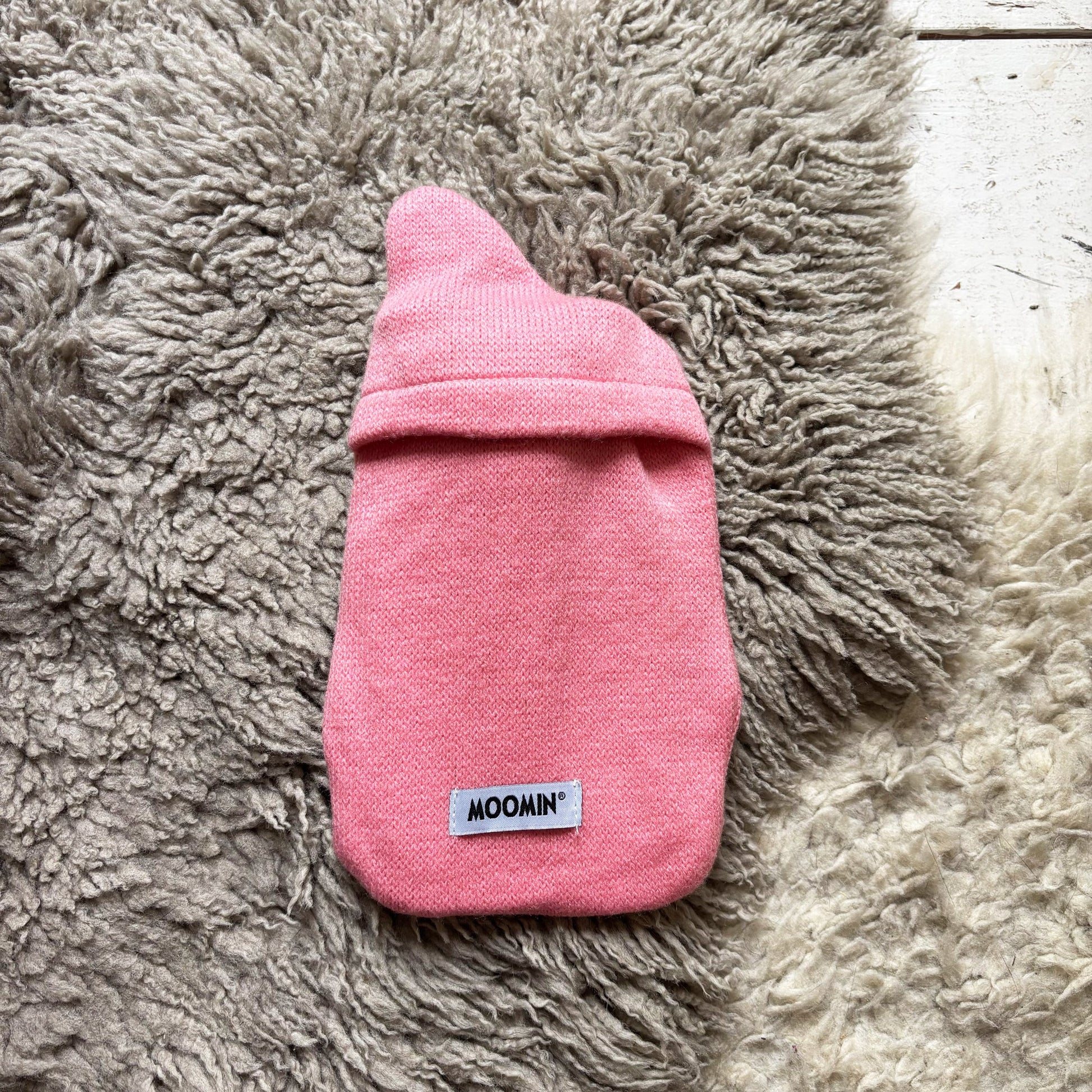 Back view of pink knit Little My Mini Hot Water Bottle with Moomin label.