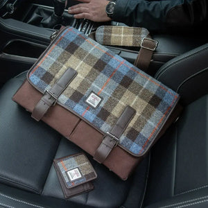 A picture of the brown and blue messenger bag sitting on a car seat.