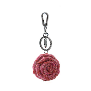 A maroon herringbone Harris Tweed rose keyring, showcasing its intricate pattern and delicate rose design.