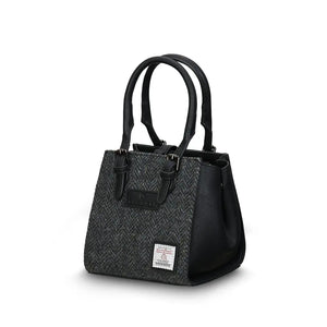 Islander Mini Caillie Tote in grey herringbone Harris Tweed, viewed from the side with a folded silhouette.