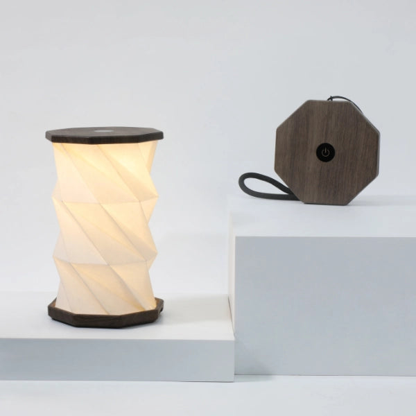 Mini Twist Hexagon Lamp glowing in open twisted form with warm LED light and wooden finish.