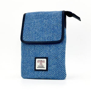 Angled view of sky blue Harris Tweed crossbody bag showing texture, flap design and compact size.