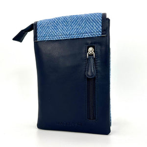 Back of mini crossbody bag featuring navy faux leather and vertical zip pocket with silver zip pull.