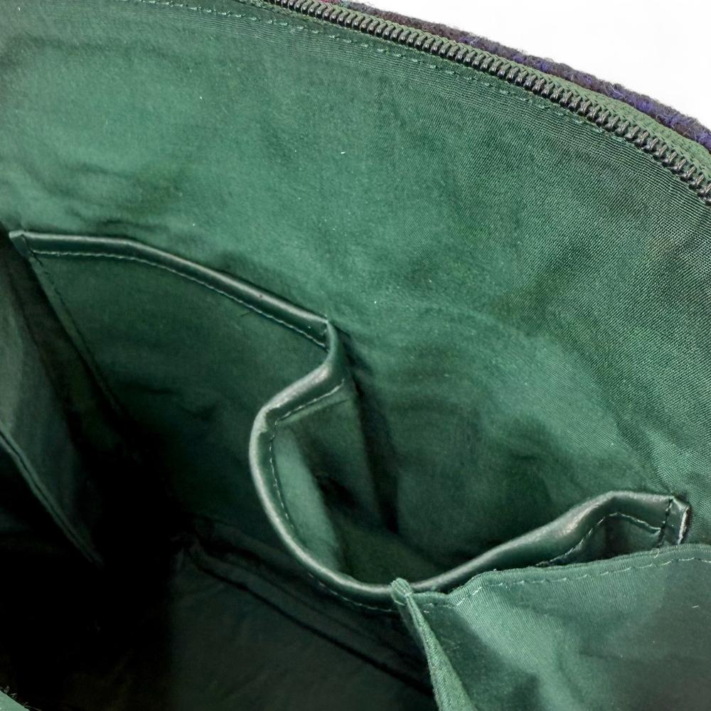 Maccessori embossed branding on dark green vegan leather back panel.