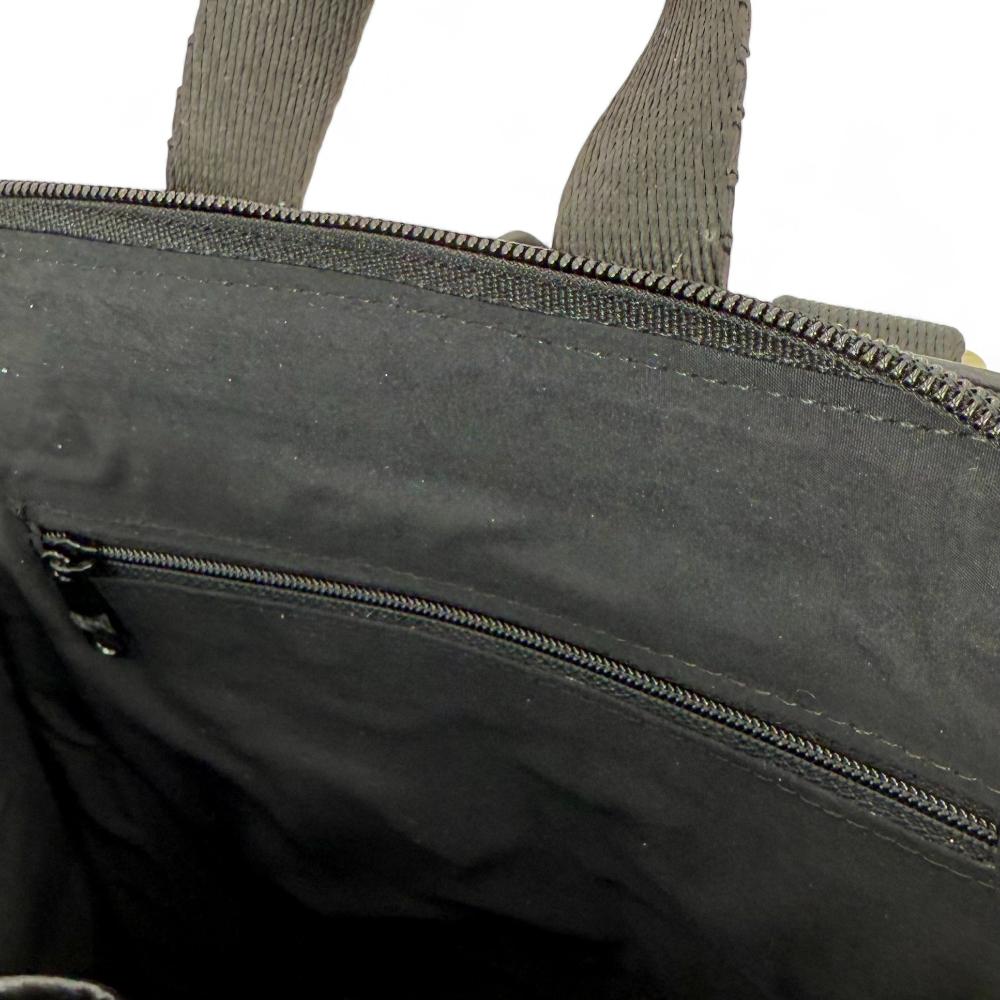 Charcoal Harris Tweed mini backpack interior showing zip pocket and lining.