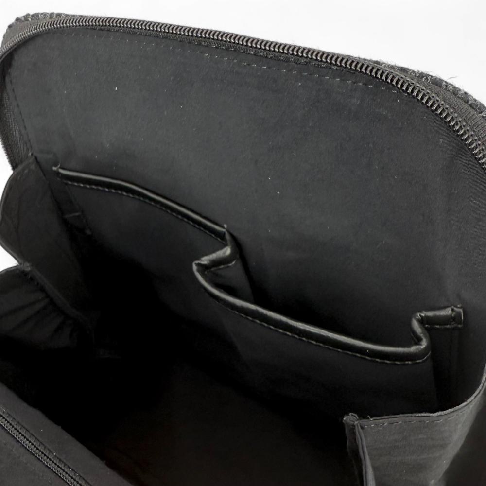 Charcoal Harris Tweed mini backpack interior showing slip pockets and compartments.