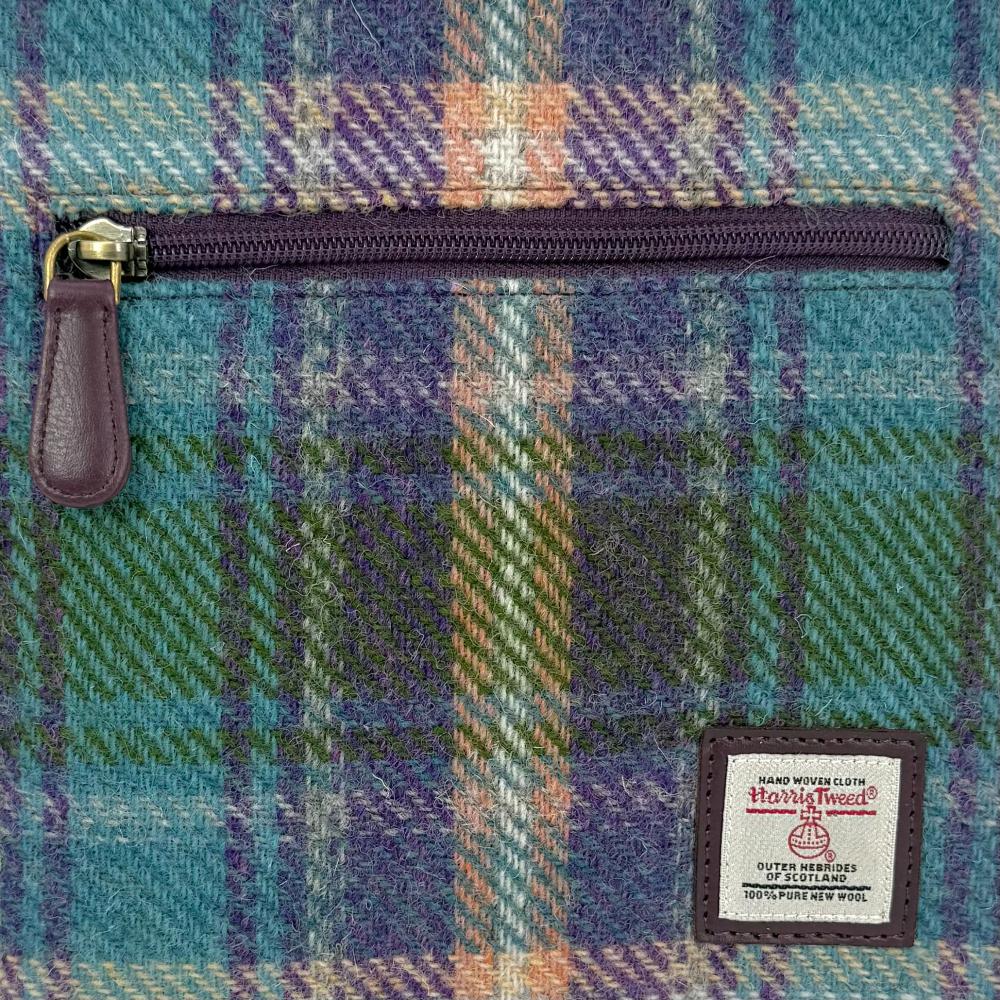 Close-up of green and purple plaid Harris Tweed plaid texture and label.