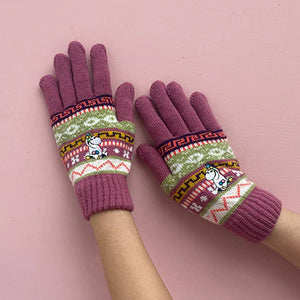 Moomin Snorkmaiden gloves laid flat on pink background, highlighting fair isle pattern and purple tones.