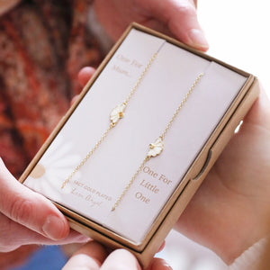 Mother and child gold flower bracelet set in a luxury gift box.