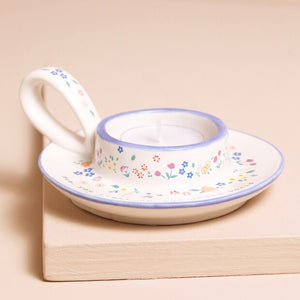 Close-up of tealight holder handle with delicate blue floral pattern.