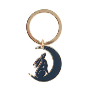 Keyring with navy hare sitting in crescent moon on backing card.