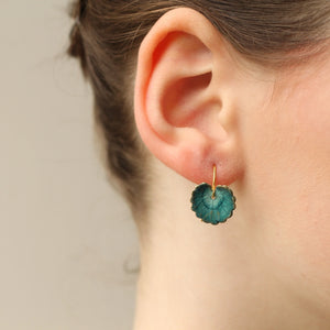 Hand-painted navy blue leaf earring with gold trim worn on ear; lightweight brass hook shows short drop length just below the earlobe.