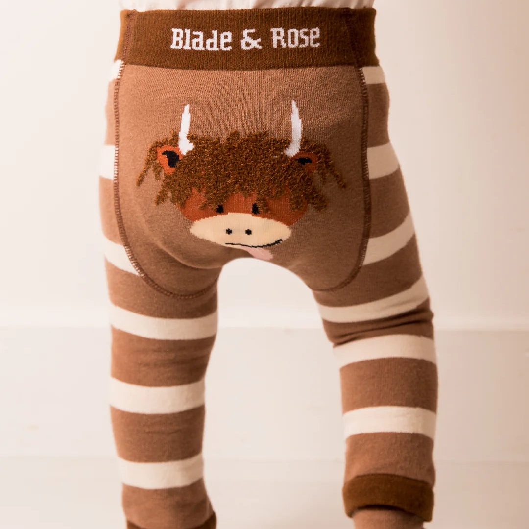 Baby wearing Neutral Highland Cow Leggings featuring Hamish Highland Cow design on the back.